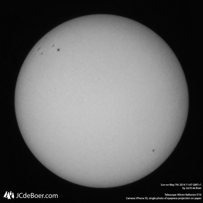 B/W image of sun. Multiple sunspots clearly visible with some texture within.
