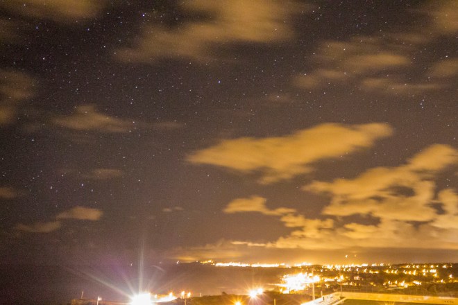 Northern shoreline of Sao Miguel at night. The bright lights in the lower left are headlights.